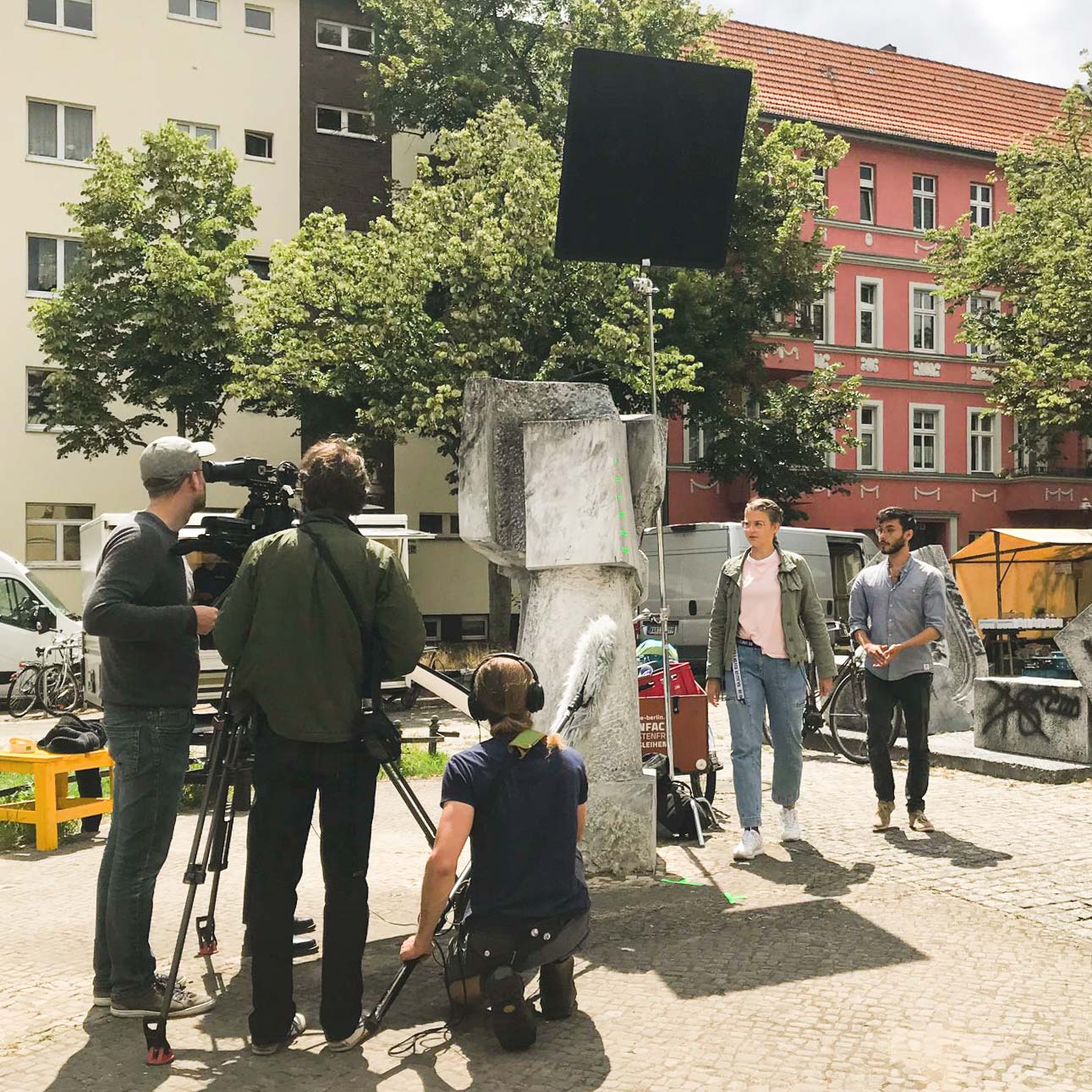 Making-Of-Foto Erklärfilm Suffizienzdetektive für Deutsche Umweltstiftung. Ein dreiköpfiges Kamerateam dreht eine Szene mit zwei Schauspieler:innen